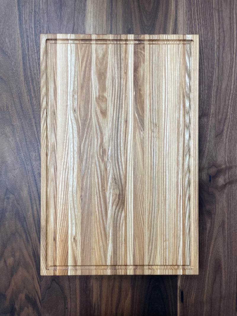 Solid ash cutting board with drip edge. Top view.