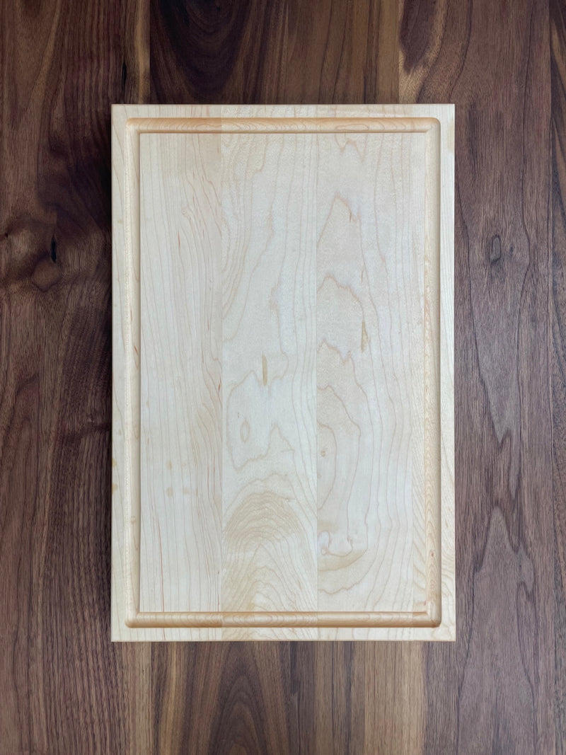 Solid maple cutting board with drip edge. Top view.