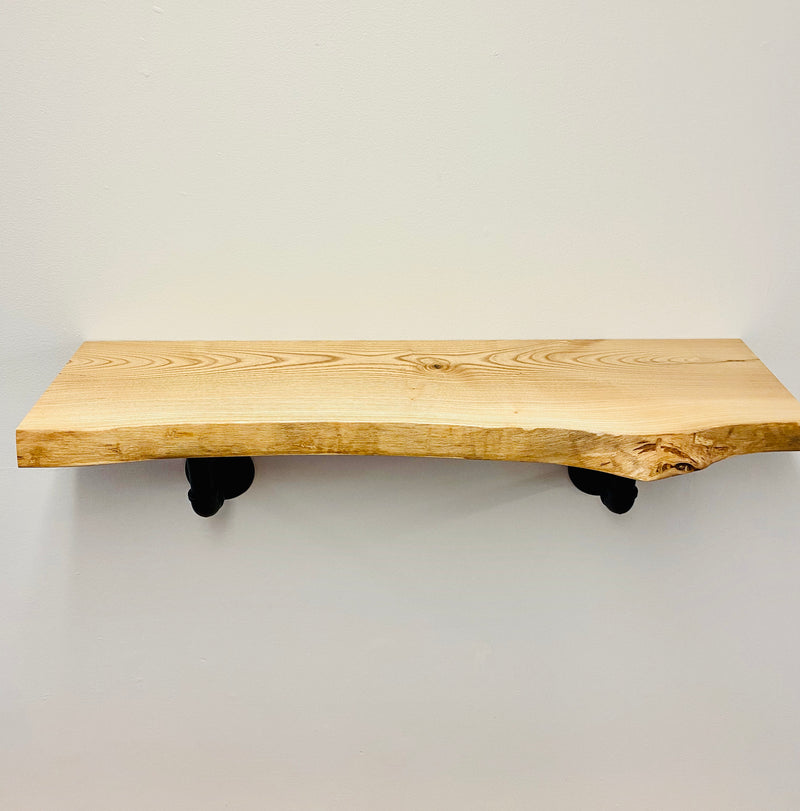 Natural edge, solid wood shelf with black pipe brackets