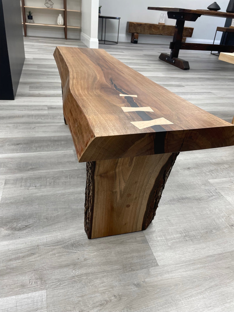 Solid black walnut bench with a live edge and maple bowties. Side view.