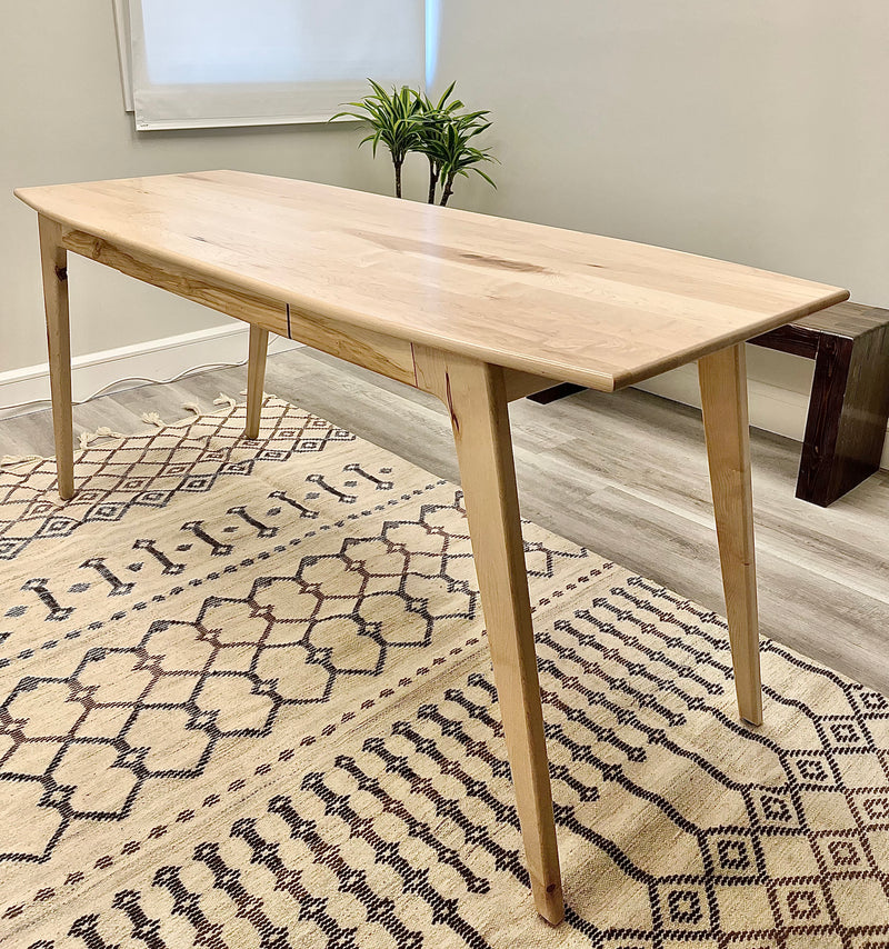 Solid maple desk with a hidden drawer and tapered legs in a natural finish