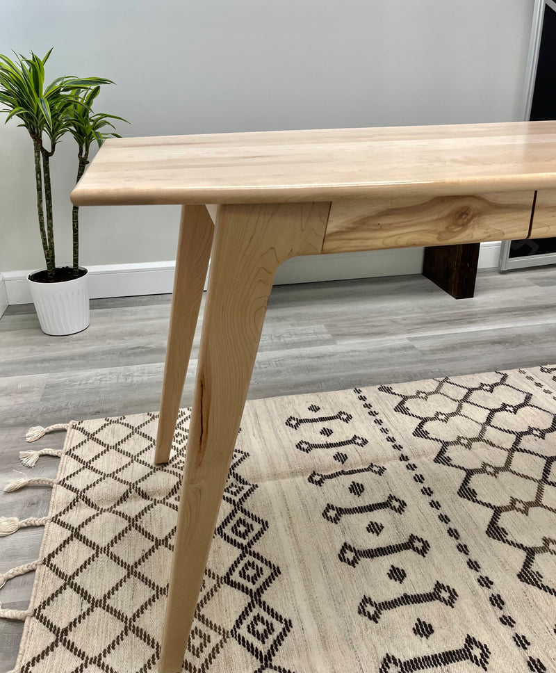 Solid maple desk with a hidden drawer and tapered legs in a natural finish