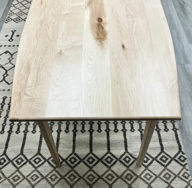 Solid maple desk with a hidden drawer and tapered legs in a natural finish. Top view . 