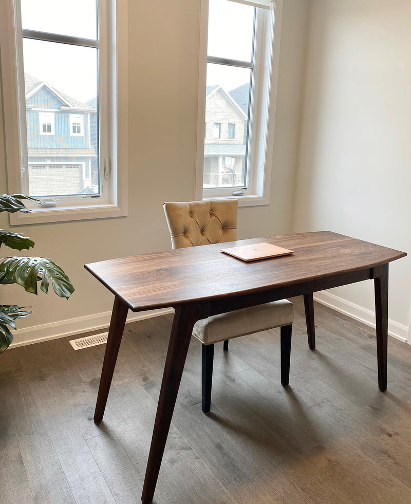 Solid walnut desk with a hidden drawer and tapered legs in a natural finish.  