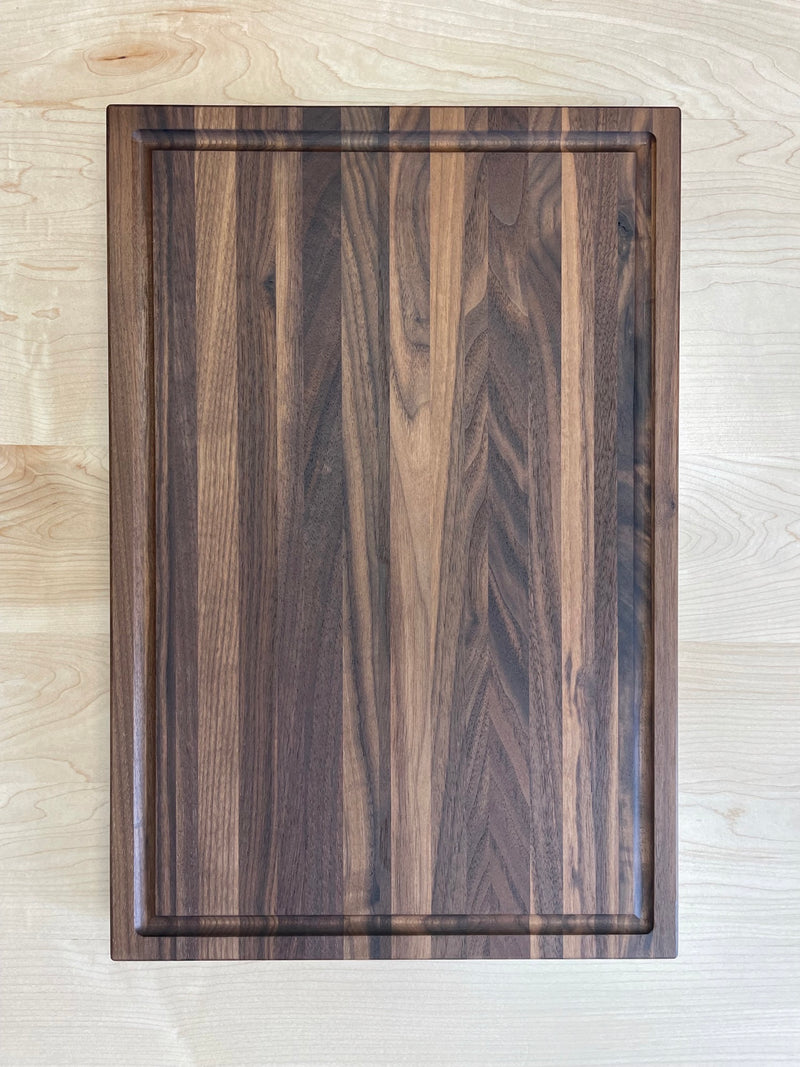 Solid walnut cutting board with drip edge. Top view.