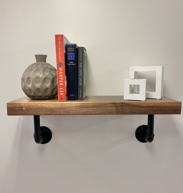 solid wood shelf with black pipe brackets with books and decor