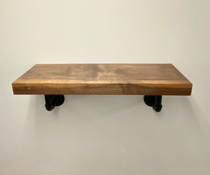 solid wood shelf with black pipe brackets