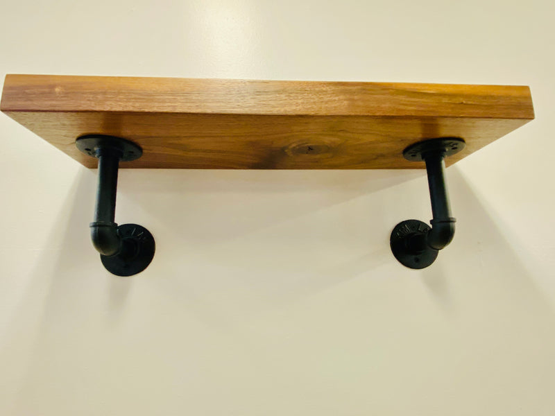 solid wood shelf with black pipe brackets